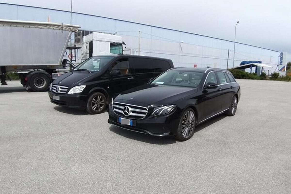 to svarte biler parkert ved siden av en lastebil