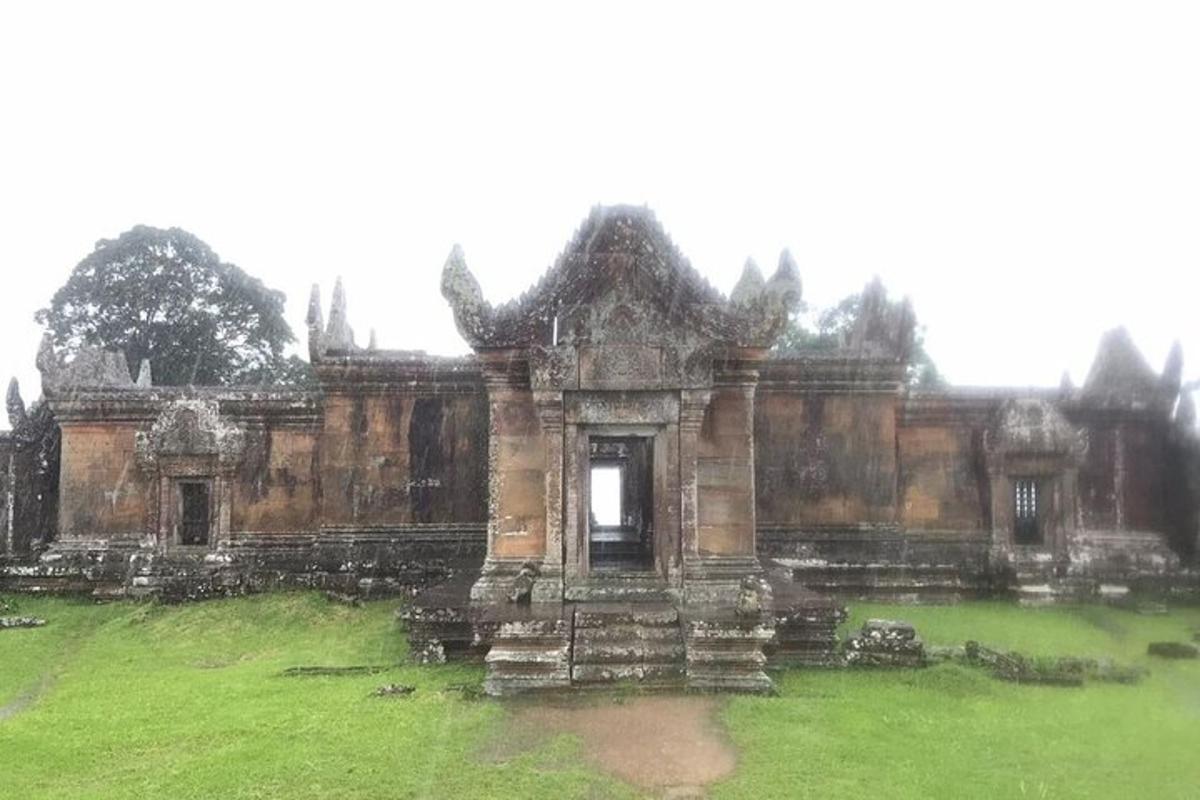 Un edificio antiguo en un campo con un campo verde.