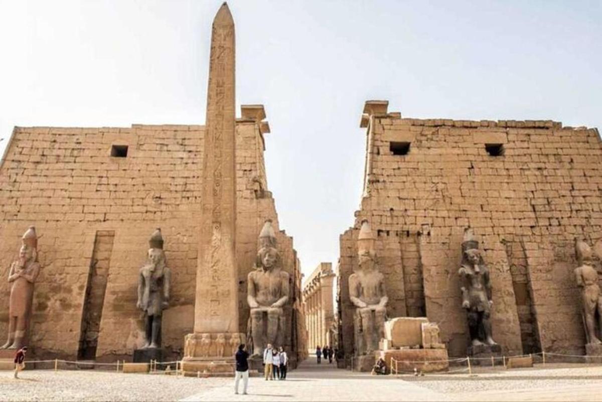 un edificio con statue di persone in piedi di fronte