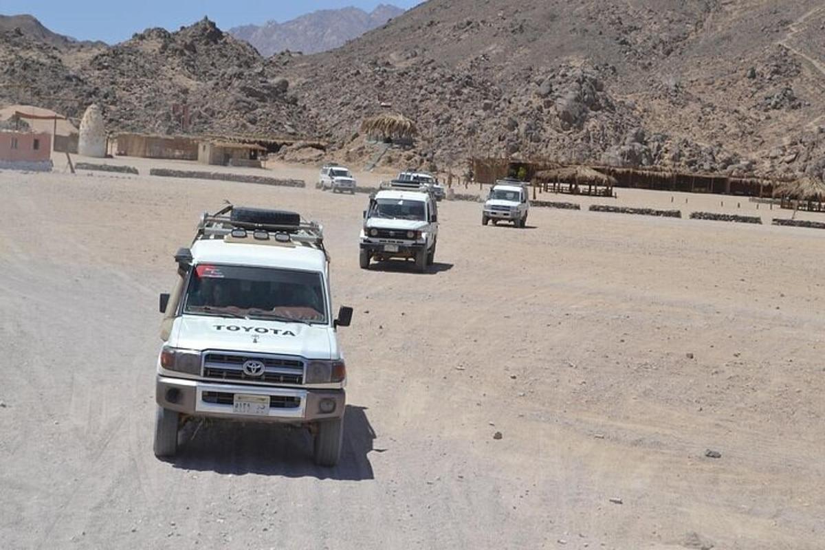 Un grupo de camiones circulando por un camino de tierra