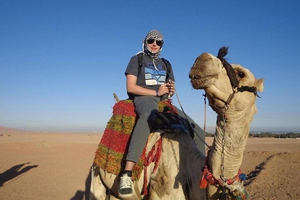 a woman riding a camel in the desert