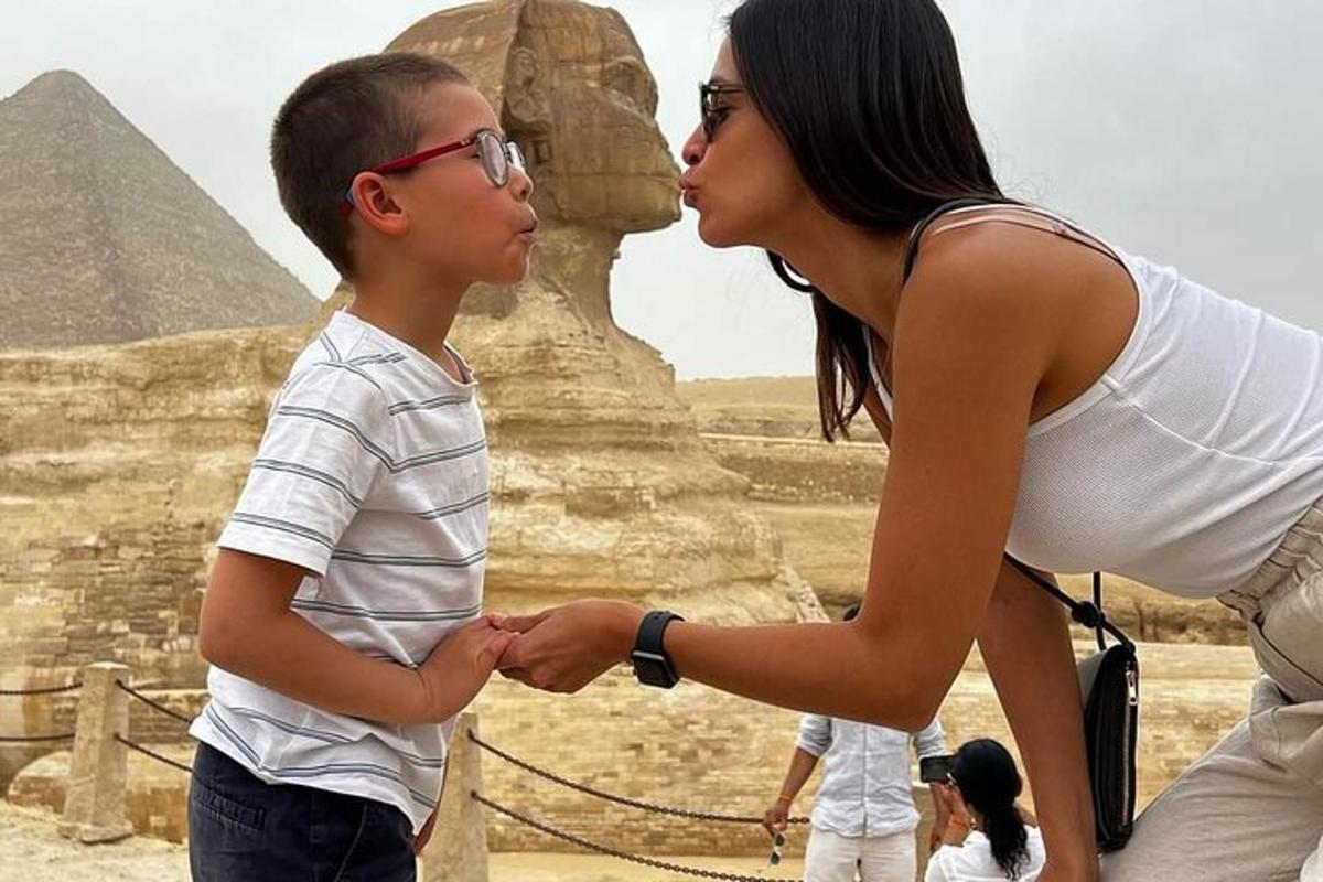 a woman and a boy standing in front of the pyramid