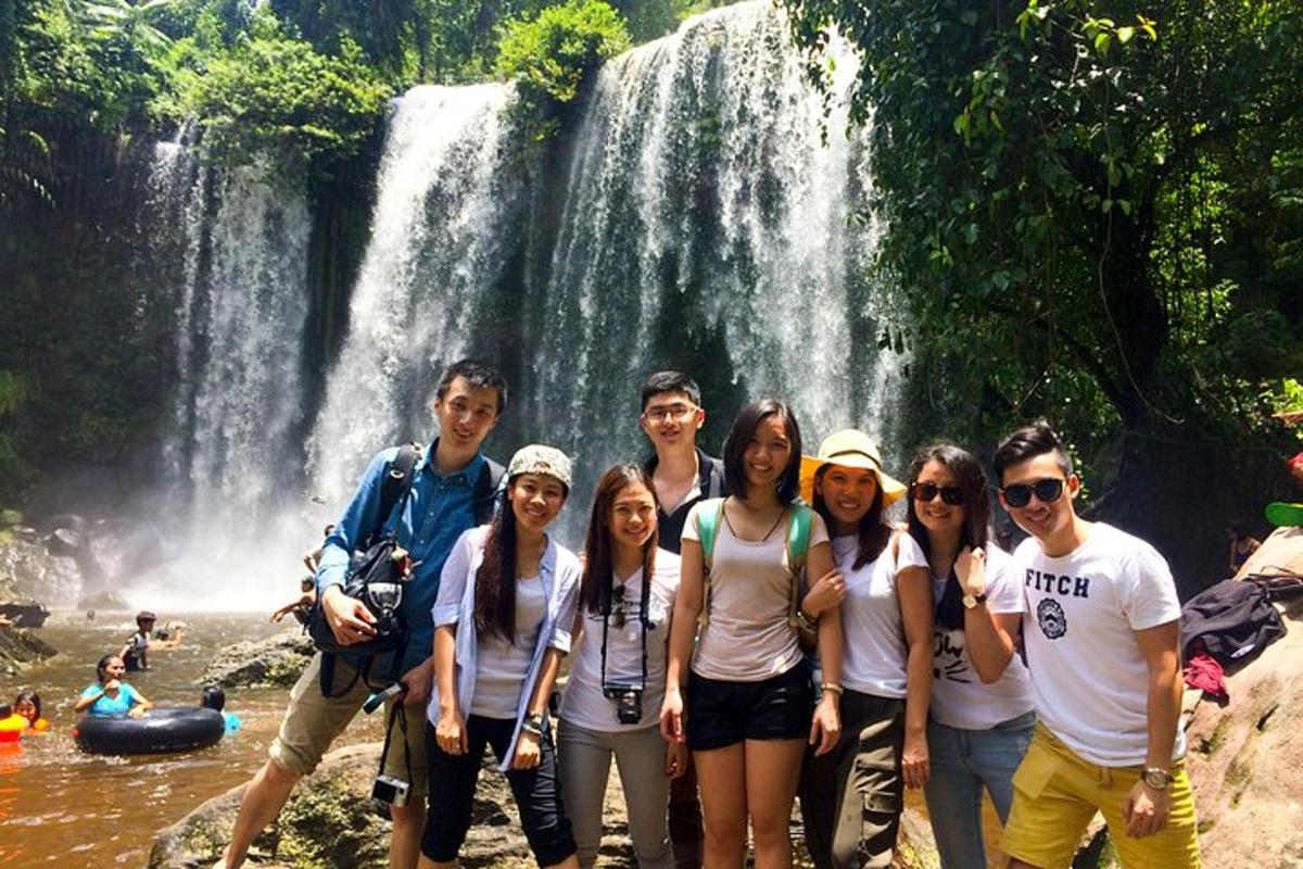 un gruppo di persone in piedi davanti a una cascata