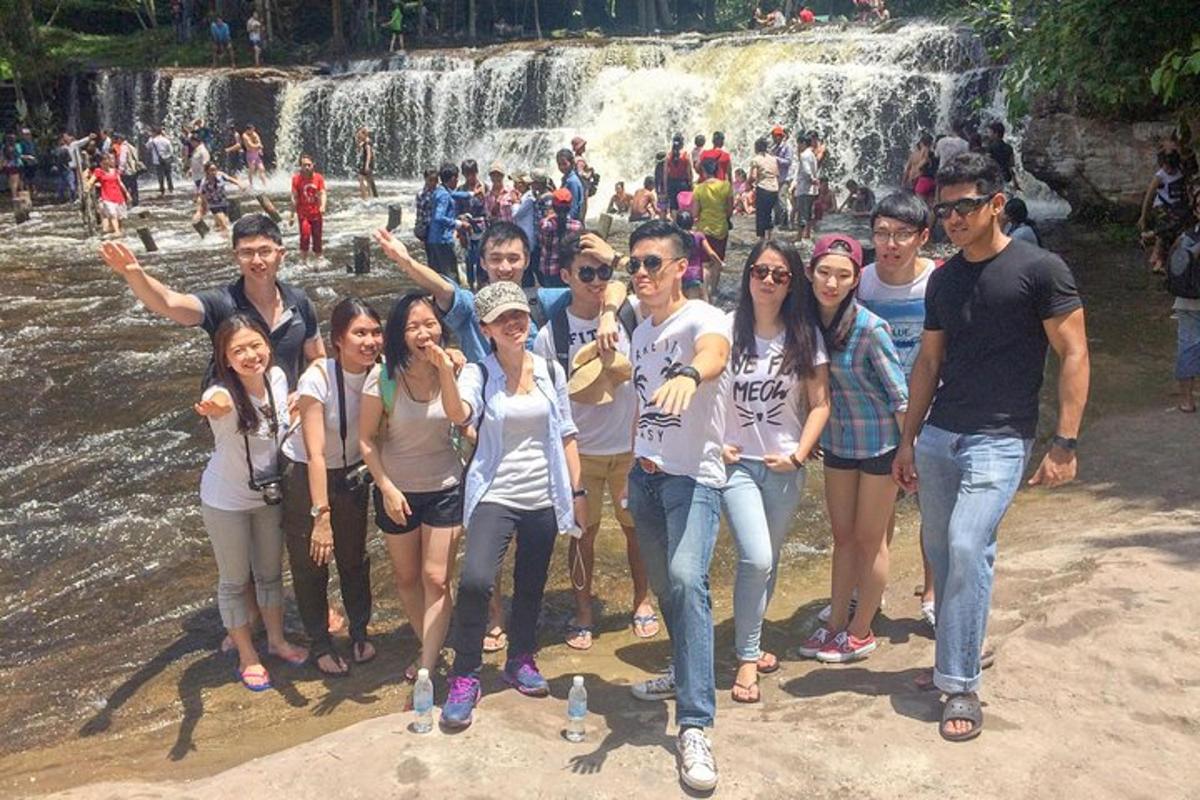 un gruppo di persone in piedi davanti a una cascata