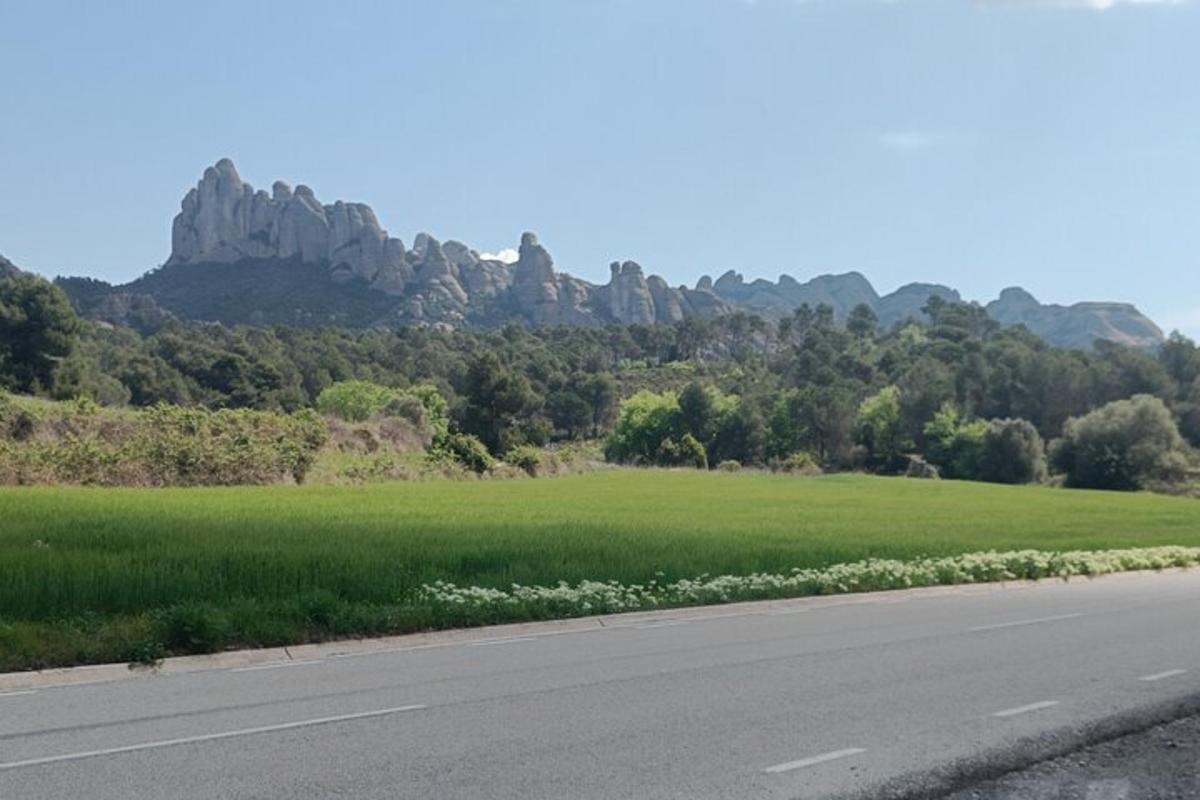 una strada vuota accanto a un campo di erba e rocce