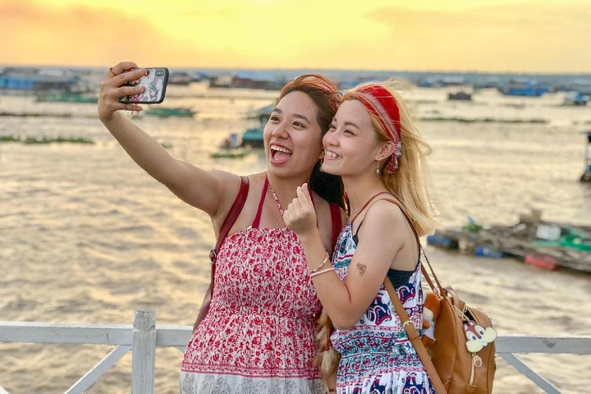 due donne in piedi una accanto all'altra che scattano una foto
