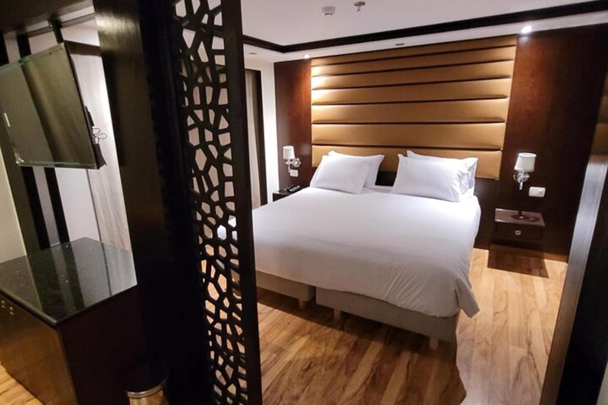 bilik tidur dengan katil putih dengan kepala katil kayu