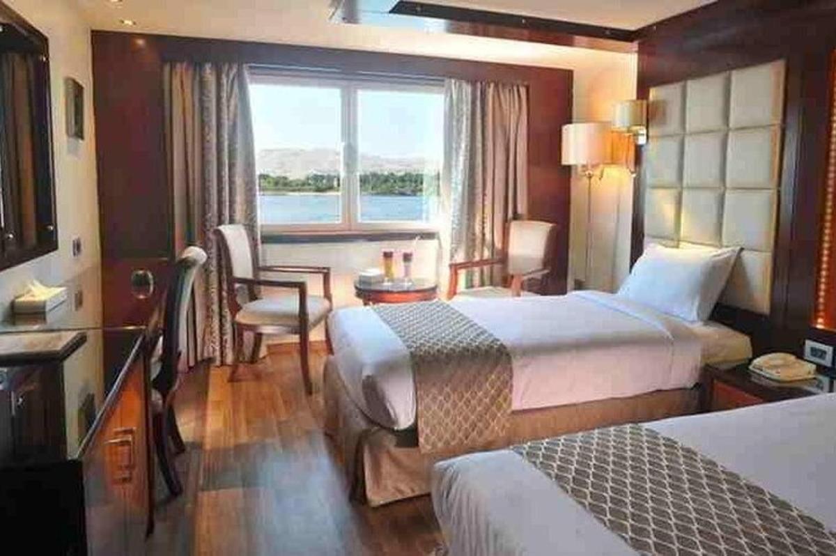 una camera d'albergo con due letti e una finestra