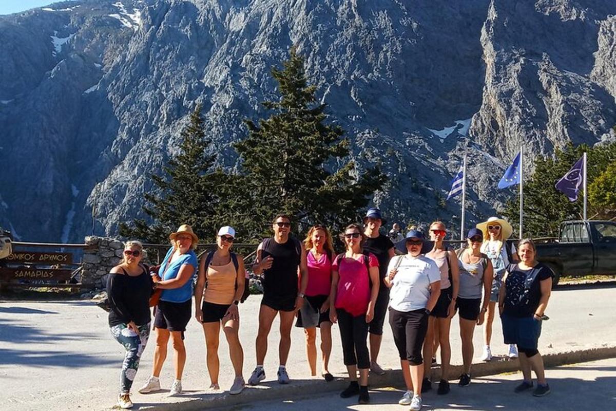 un grup de oameni care pozează pentru o fotografie în fața unui munte