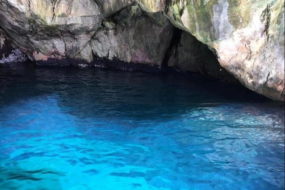 басейн з блакитною водою поруч зі скельною печерою