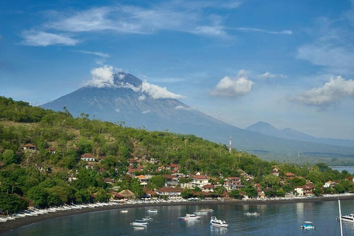 a mountain with a town and boats in the water
