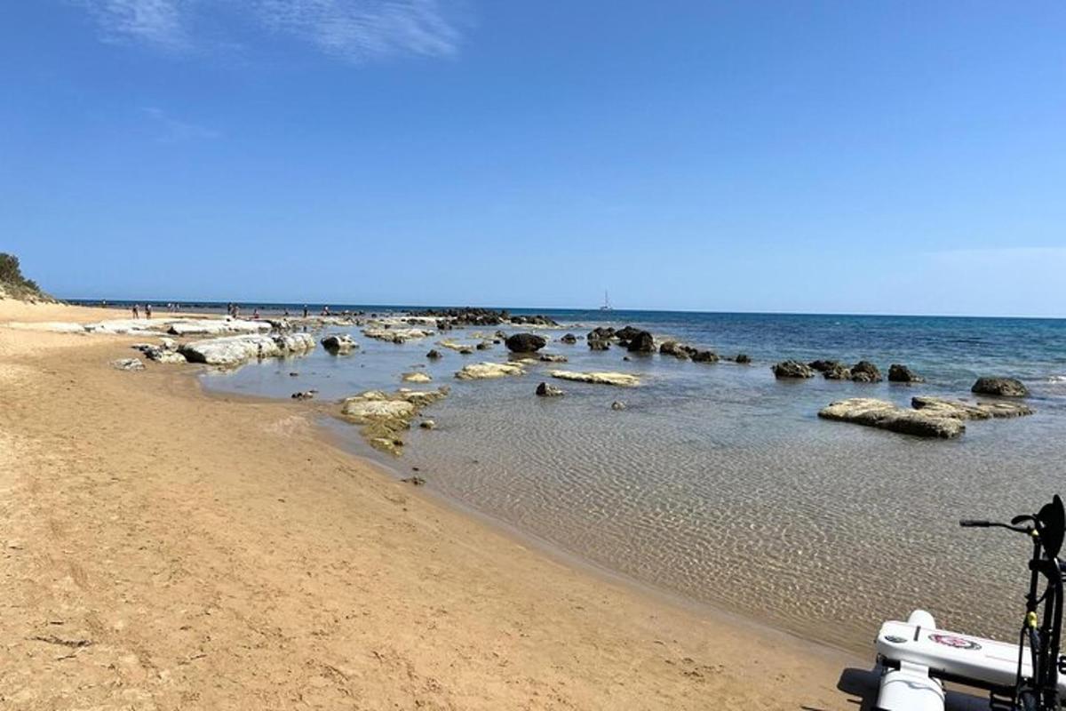 uma praia com algumas pedras na água