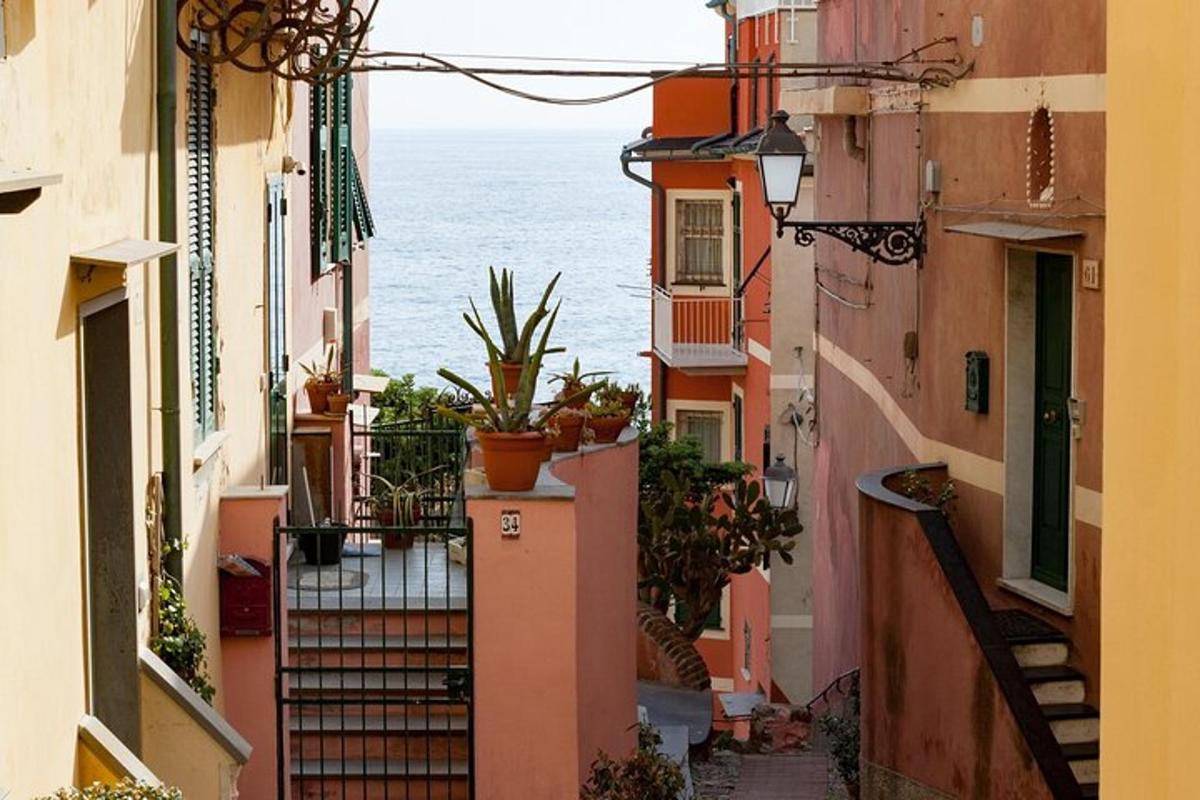 Un callejón con vista al océano desde entre edificios.