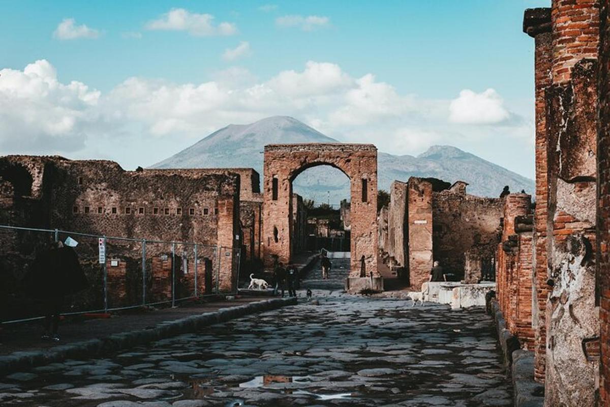 un vecchio edificio con un arco e una montagna sullo sfondo