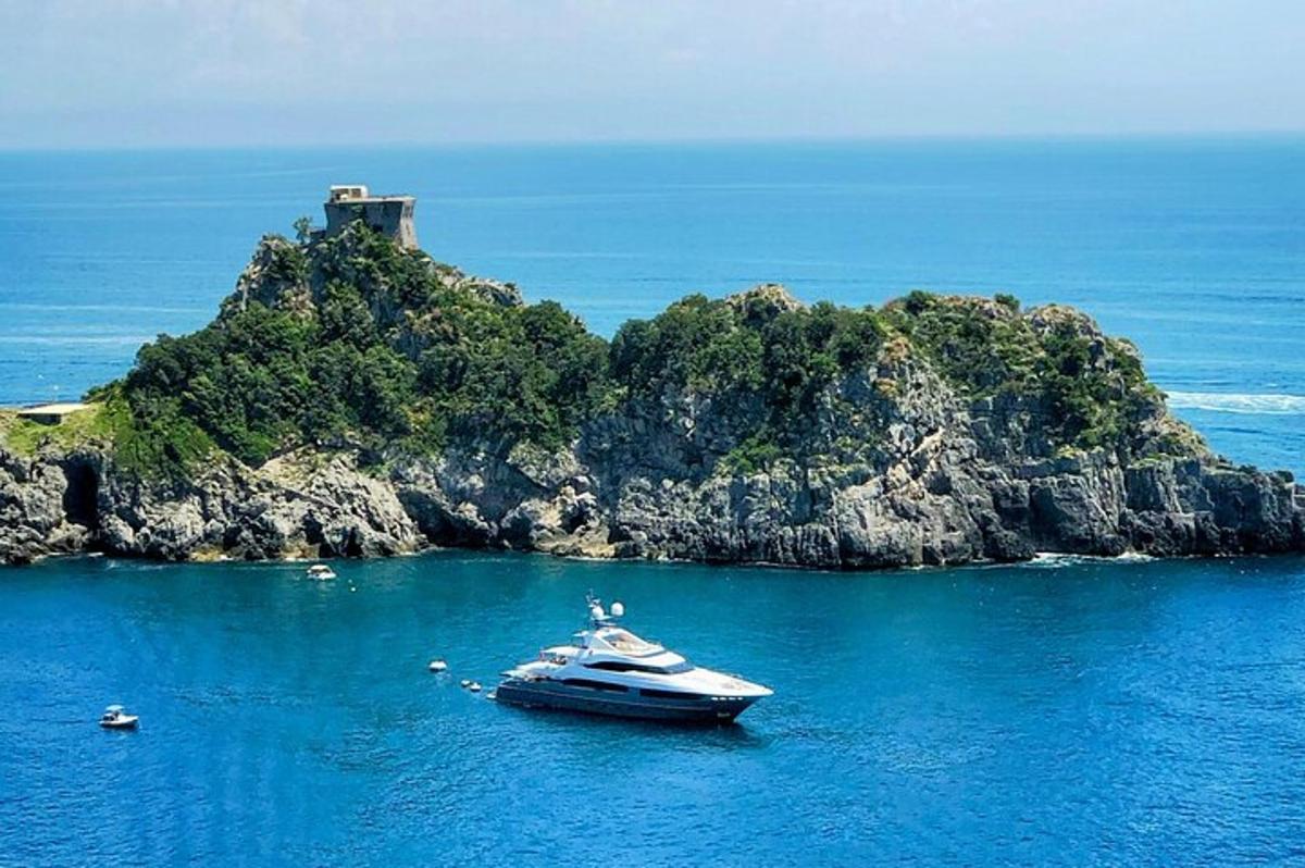 una barca in acqua vicino a una piccola isola