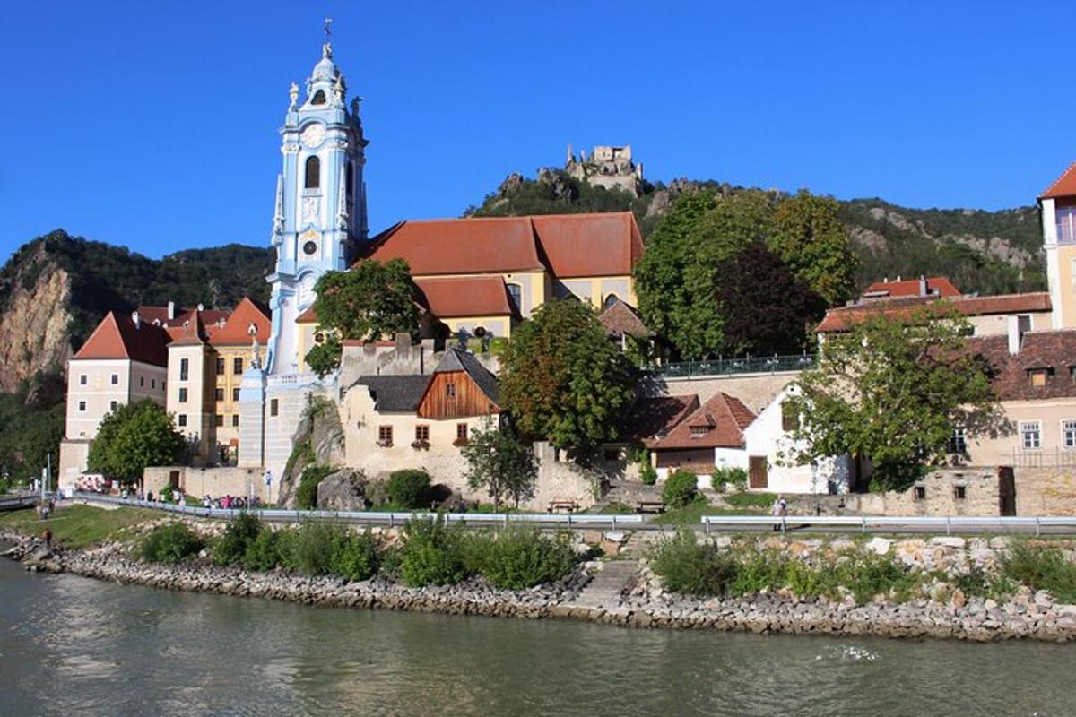 un grande edificio con una torre dell'orologio accanto a un fiume