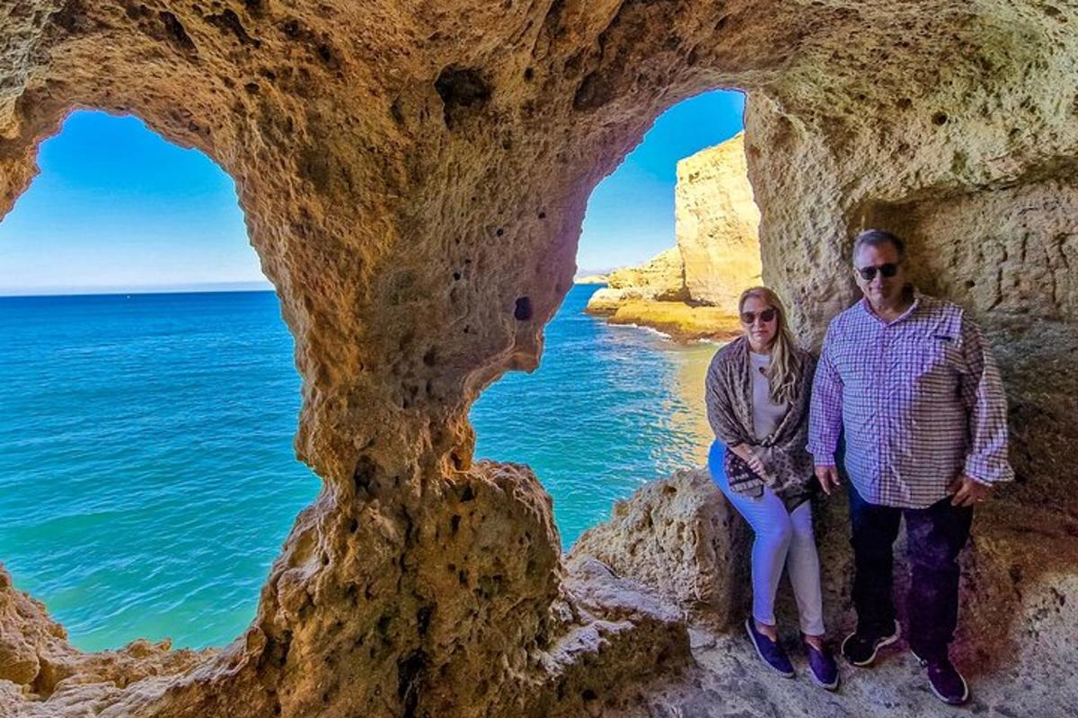un uomo e una donna in piedi in una grotta nell'oceano
