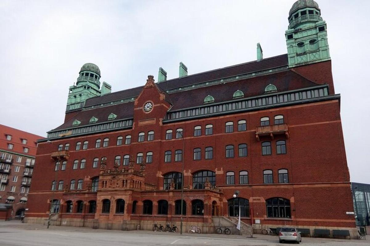 un grand bâtiment en briques rouges avec une tour d'horloge