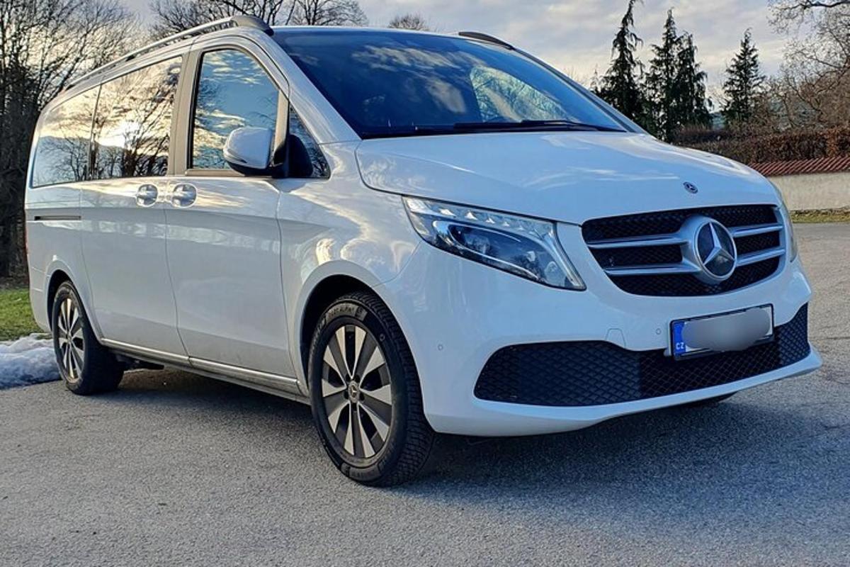 Un coche Mercedes blanco estacionado en un estacionamiento