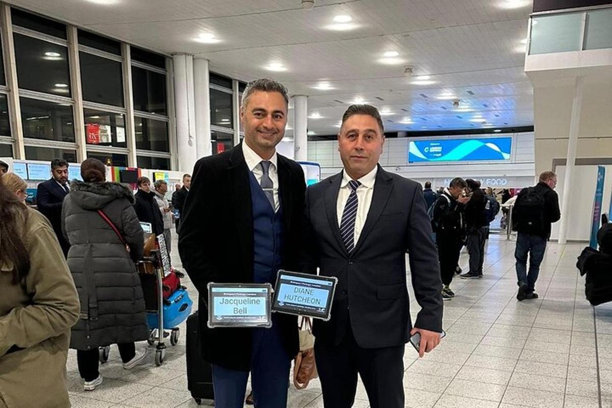 dois homens de terno segurando certificados em um aeroporto