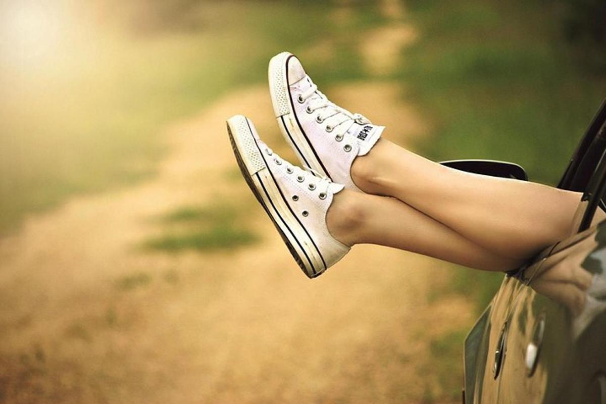 μια γυναίκα με τα πόδια της να προεξέχουν από ένα ζευγάρι παπούτσια