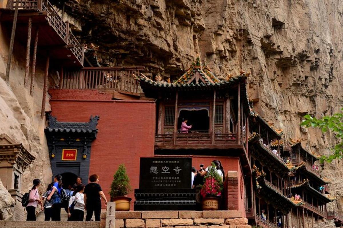people standing outside of a building on a mountain