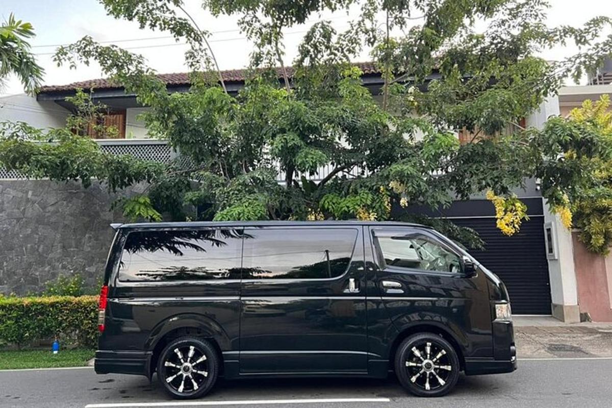 uma van preta estacionada em frente a uma casa