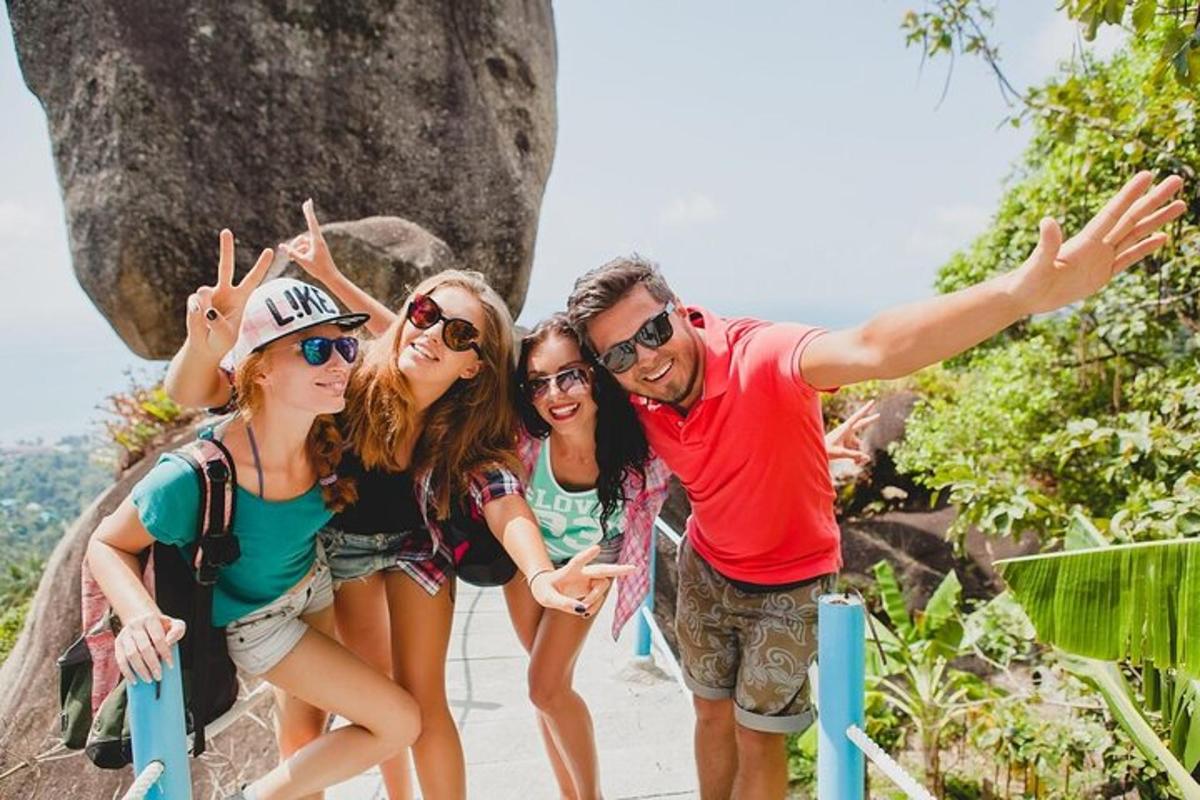um grupo de pessoas posando para uma foto em frente a uma rocha