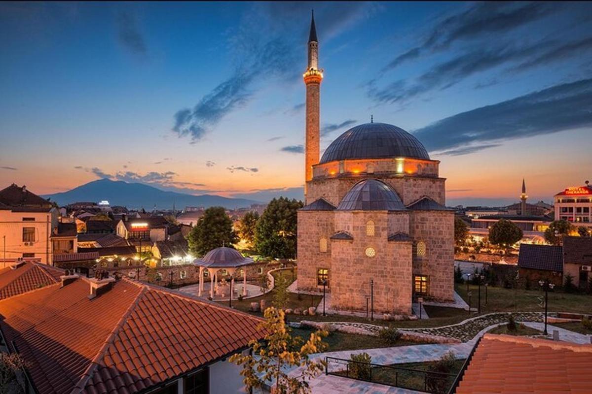 o moschee cu minaret într-un oraș la amurg