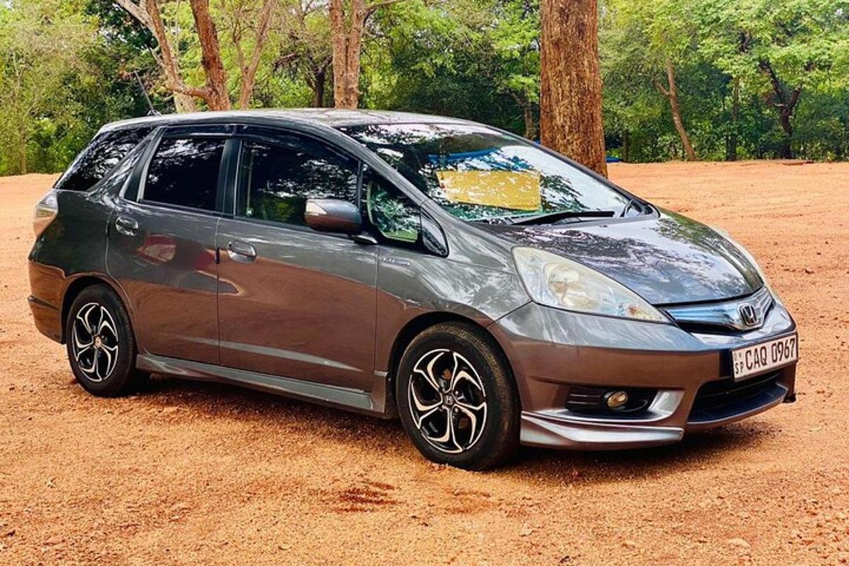 a small silver car parked on a dirt field
