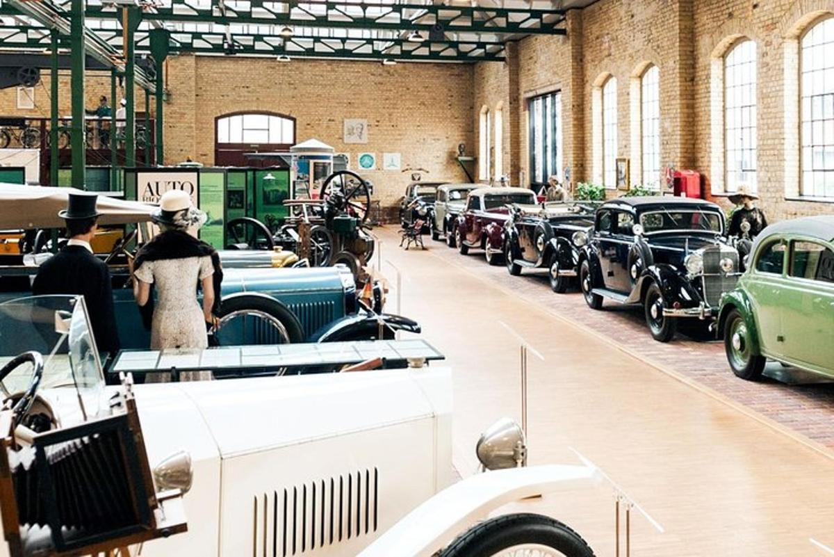 a row of antique cars on display in a building