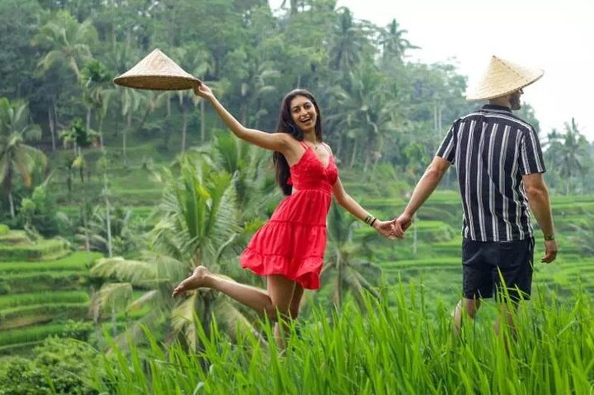 un uomo e una donna che camminano in un campo con un cappello