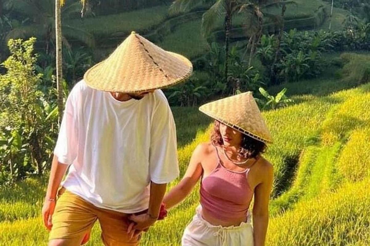 un uomo e una donna che indossano cappelli che camminano in un campo