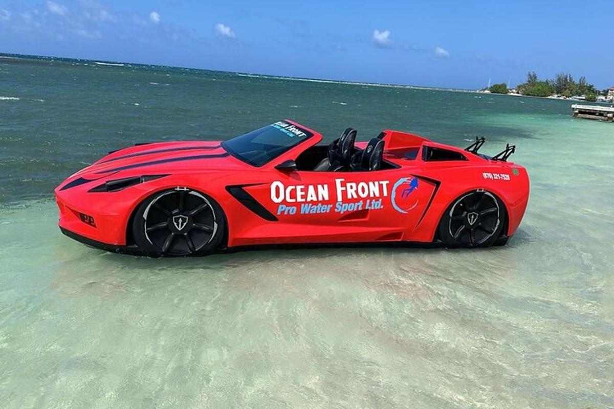 a red car sitting in the water on a beach