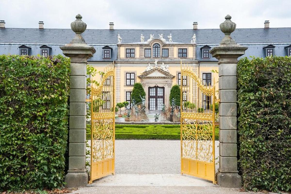 um portão ornamentado para uma casa grande com arbustos