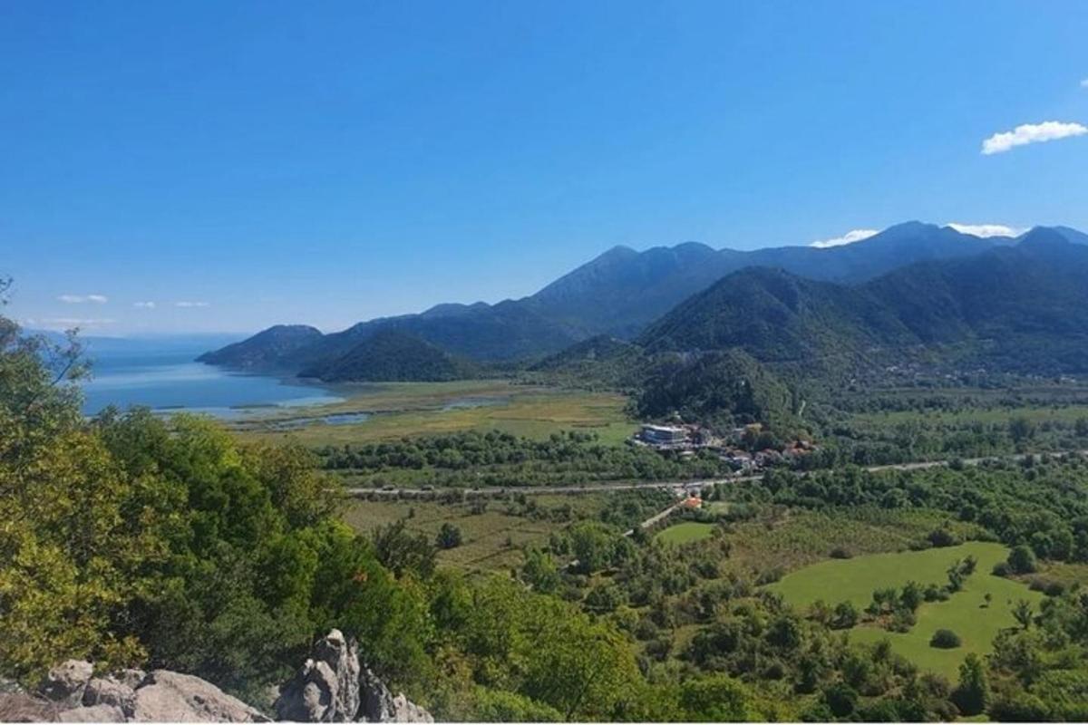 a view of a valley with a lake and mountains