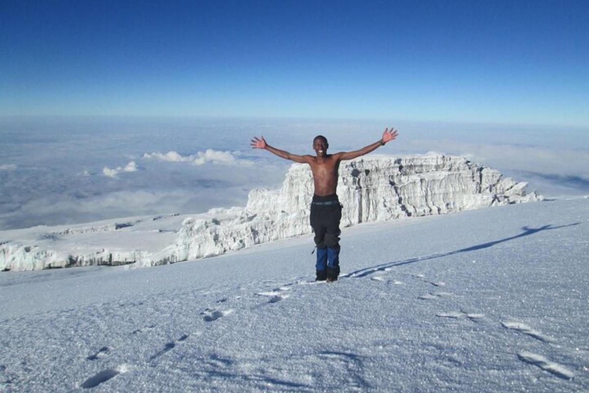 un uomo in piedi sulla cima di una montagna coperta di neve