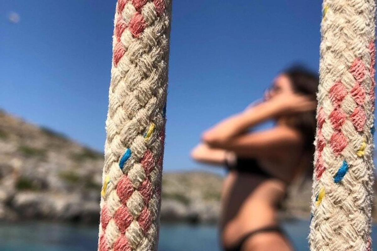 Žena v bikinách se na sebe dívá do zrcadla