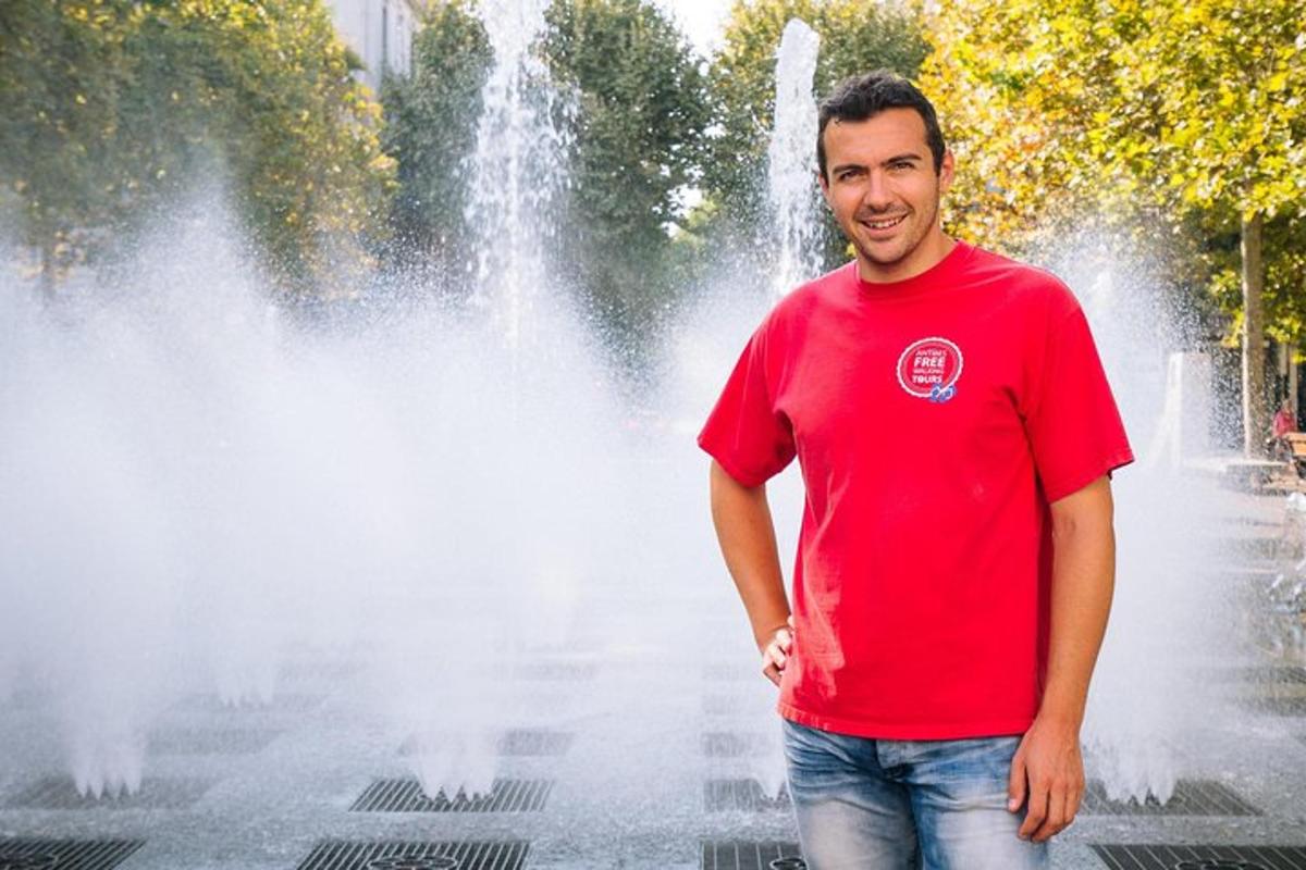 un uomo con una camicia rossa in piedi davanti a una fontana