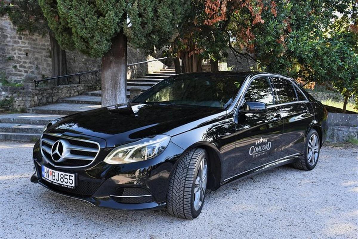 um carro preto estacionado ao lado de uma árvore