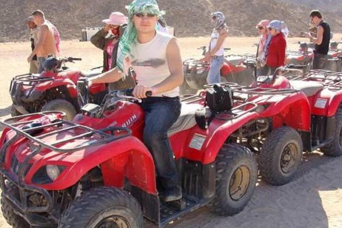 seorang wanita duduk di atas atv empat roda berwarna merah
