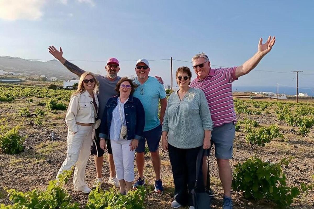 a group of people posing for a picture in a vineyard