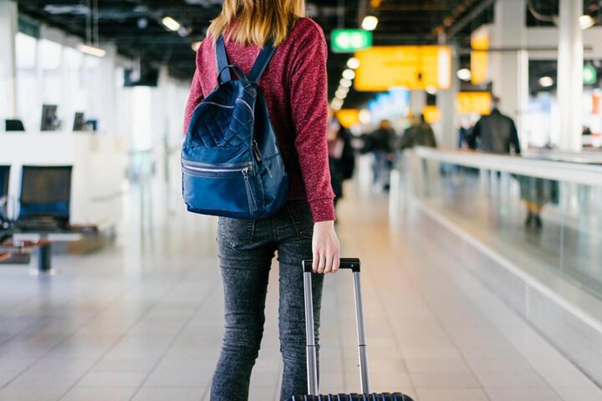 uma mulher está puxando uma mala em um aeroporto