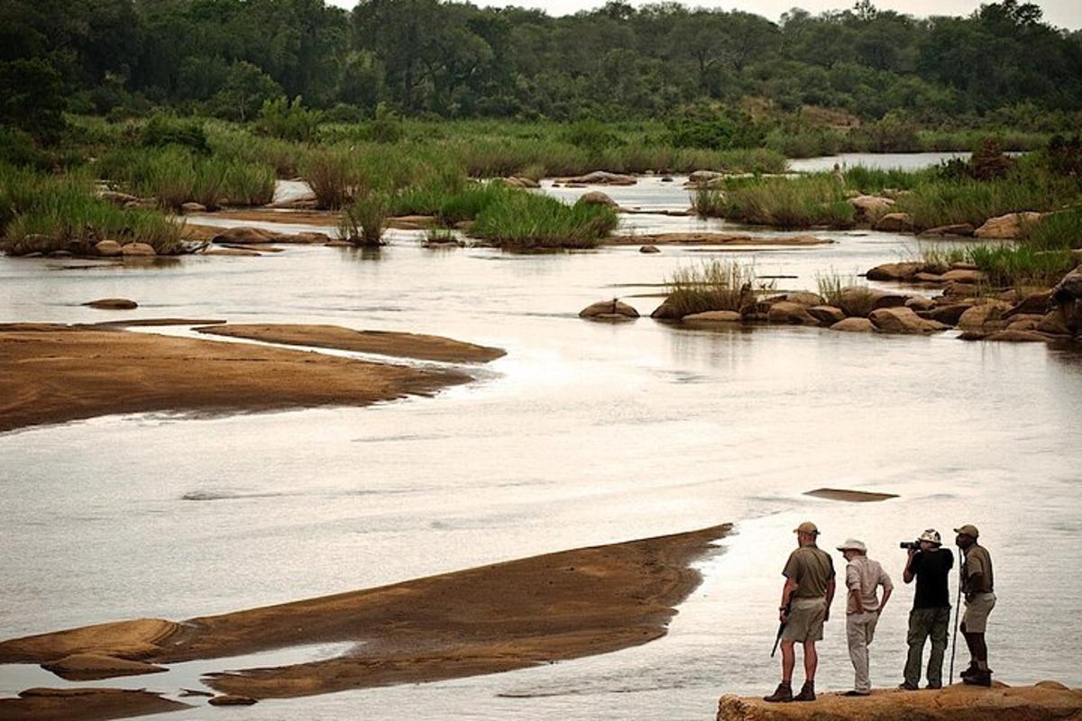 a group of people standing on the edge of a river