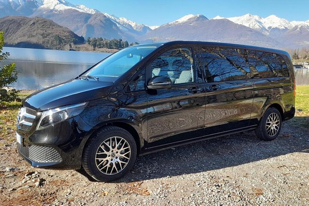 črn kombi parkiran pred jezerom