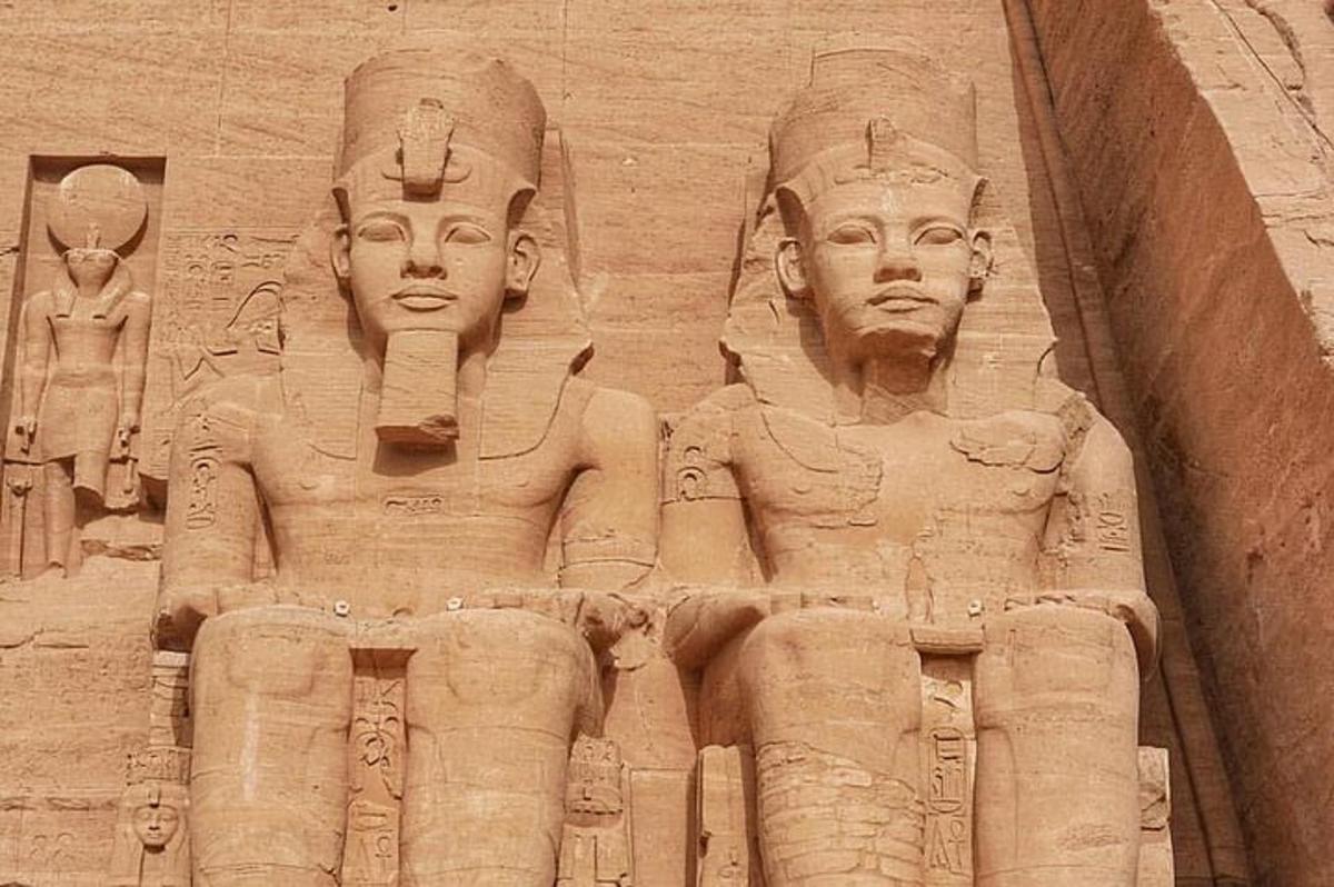 a stone wall with three statues on it