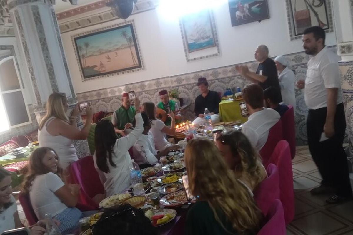 μια ομάδα ανθρώπων που κάθονται γύρω από ένα τραπέζι με φαγητό