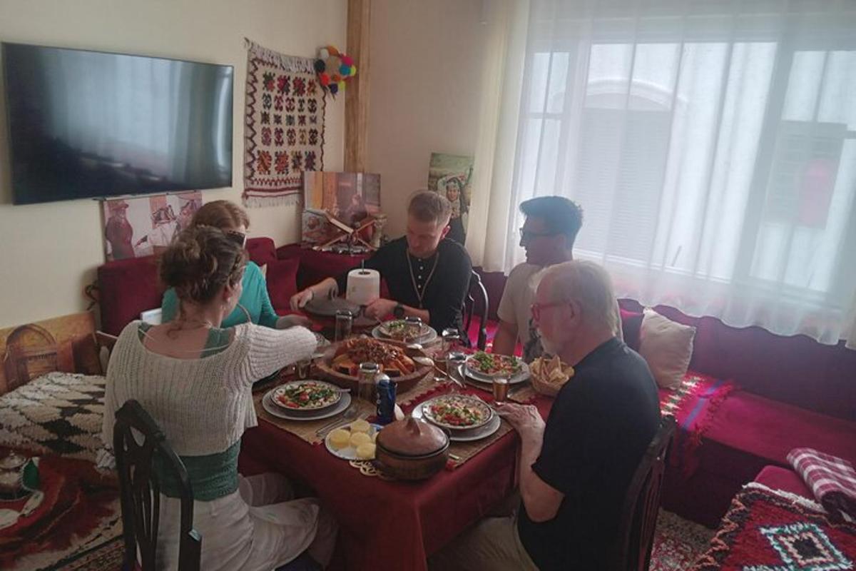 grupp inimesi, kes istuvad laua ümber ja söövad toitu