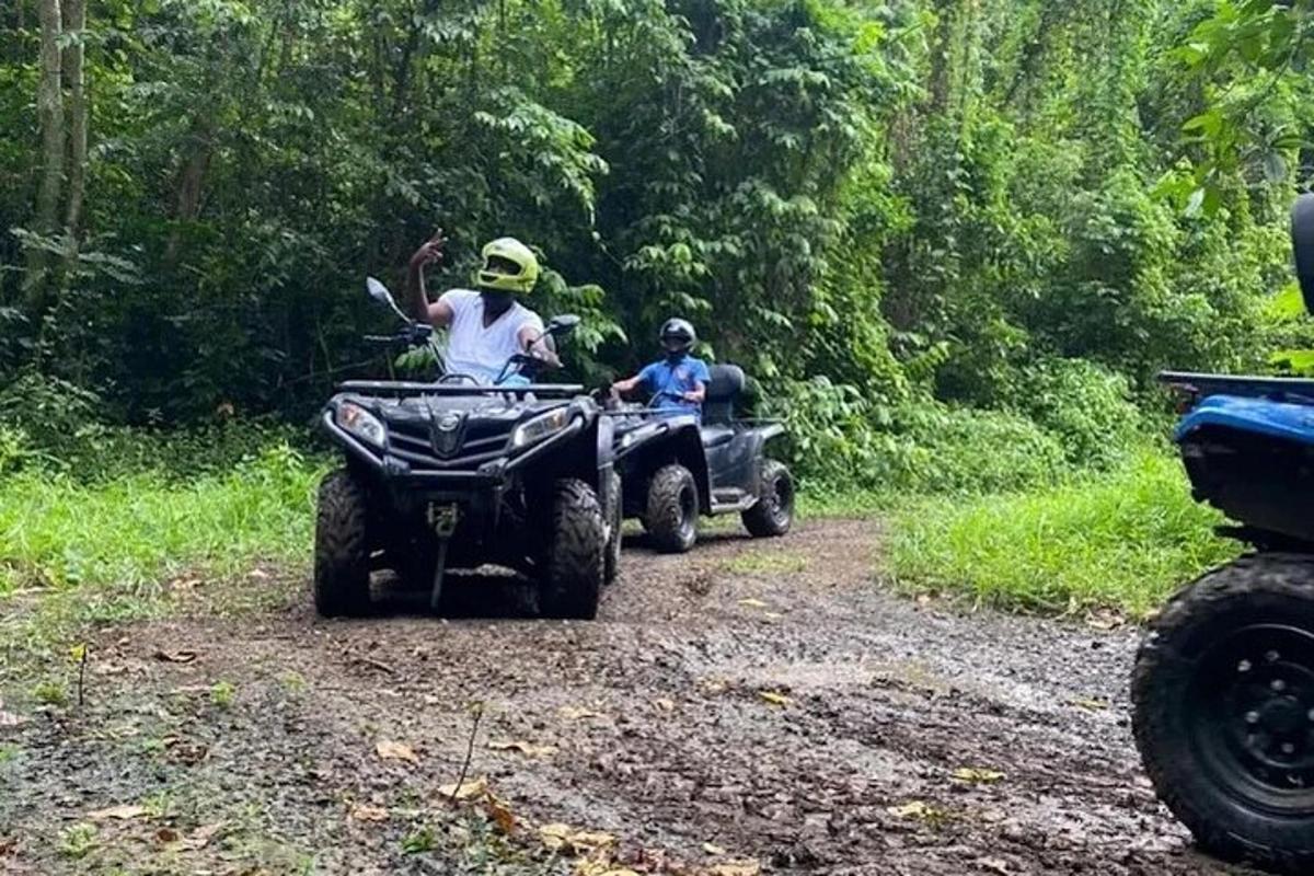 două persoane care călătoresc cu ATV-uri pe un drum de pământ