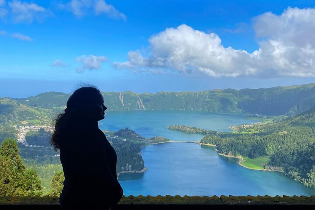 žena stojaca na rímse a pozerajúca sa na jazero